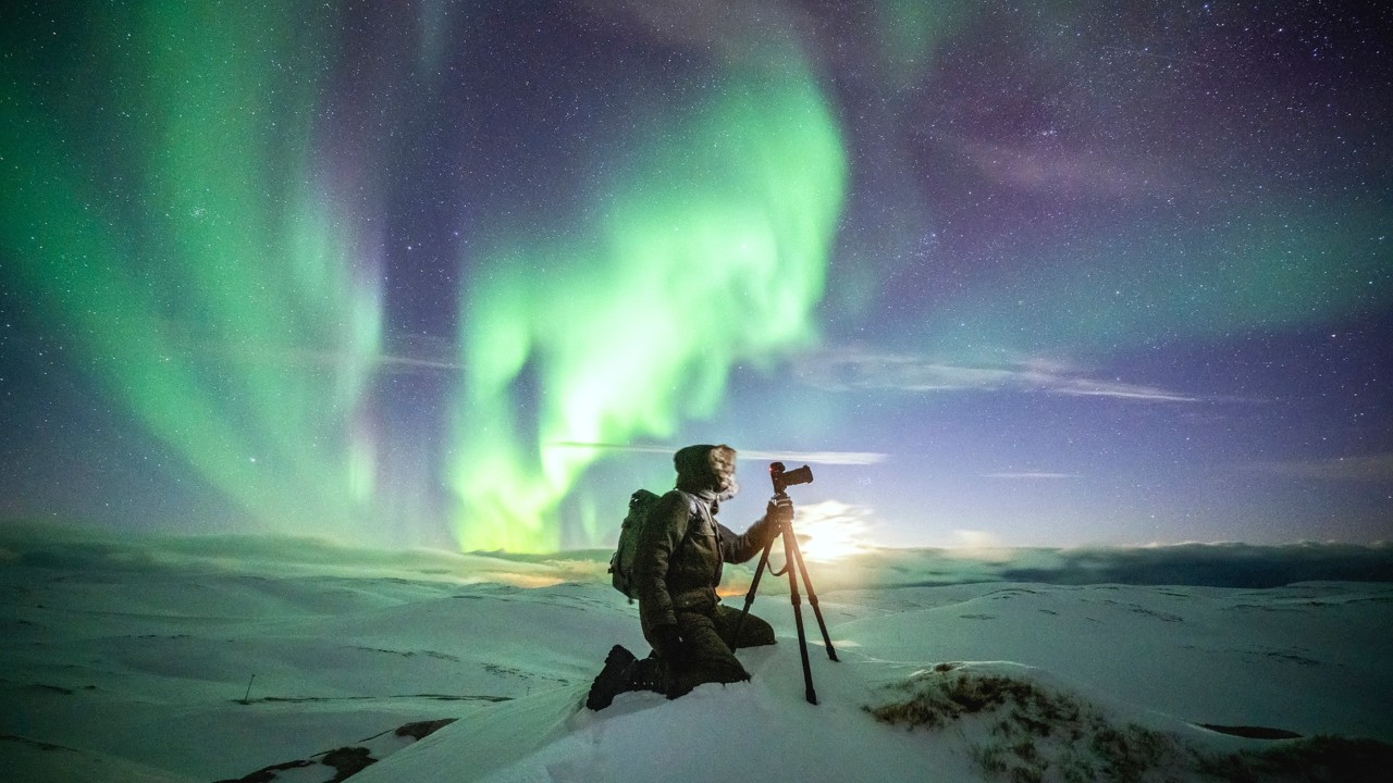 Person photographing the aurora borealis.